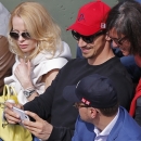 Swedish PSG striker Zlatan Ibrahimovic, center right with red cap, takes a selfie with the phone of a fan, right, as he watches the second round match of the French Open tennis tournament between Serbia's Novak Djokovic and Luxembourg's Gilles Muller at the Roland Garros stadium, in Paris, France, Thursday, May 28, 2015. Left is Ibrahimovic's wife Helena Seger. (AP Photo/Francois Mori)