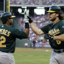 Oakland Athletics' Yoenis Cespedes (52) congratulates John Jaso (5) on his solo home run that came off a pitch from Texas Rangers' Yu Darvish in the second inning of a baseball game Tuesday, June 18, 2013, in Arlington, Texas. (AP Photo/Tony Gutierrez)