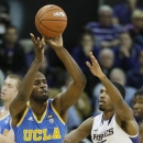 UCLA's Shabazz Muhammad (15) passes around the defense of Washington's Scott Suggs (15) during the first half of an NCAA college basketball game, Saturday, March 9, 2013, in Seattle. (AP Photo/Ted S. Warren)