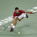 Novak Djokovic of Serbia returns a shot during match against Roger Federer of Switzerland during their men's singles semifinal match at the Shanghai Masters Tennis Tournament in Shanghai, China, Saturday, Oct. 11, 2014. (AP Photo/Vincent Thian)