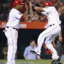 Los Angeles Angels' Vernon Wells, left, and Alberto Callaspo celebrate after they scored on a single by Chris Iannetta in the fourth inning of a baseball game against the Texas Rangers in Anaheim, Calif., Tuesday, Sept. 18, 2012. (AP Photo/Jae C. Hong)