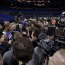 New York Knicks forward Carmelo Anthony, at left, is surrounded by members of the media as he speaks before the start of a training session at the 02 arena in London, Wednesday, Jan. 16, 2013. The Detroit Pistons are due to play a 