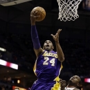 Los Angeles Lakers' Kobe Bryant (24) shoots against Milwaukee Bucks' J.J. Redick, left, and Samuel Dalembert during the first half of an NBA basketball game, Thursday, March 28, 2013, in Milwaukee. (AP Photo/Jeffrey Phelps)