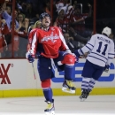 Washington Capitals left wing Alex Ovechkin (8), from Russia, celebrates his goal as Toronto Maple Leafs center Jay McClement (11) skates behind in the second period of an NHL hockey game Tuesday, April 16, 2013 in Washington. (AP Photo/Alex Brandon)
