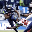 Seattle Seahawks' Marshawn Lynch leaps to try and avoid a tackle from cornerback Leonard Johnson in the second half of an NFL football game Sunday, Nov. 3, 2013, in Seattle. The Seahawks won 27-24 in overtime. (AP Photo/Elaine Thompson)