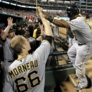 Pittsburgh Pirates' Marlon Byrd, right, is congratulated in the dugout by Justin Morneau (66) and others after scoring on a double by Pedro Alvarez in the seventh inning of a baseball game against the Texas Rangers, Monday, Sept. 9, 2013, in Arlington, Texas. (AP Photo/Tony Gutierrez)