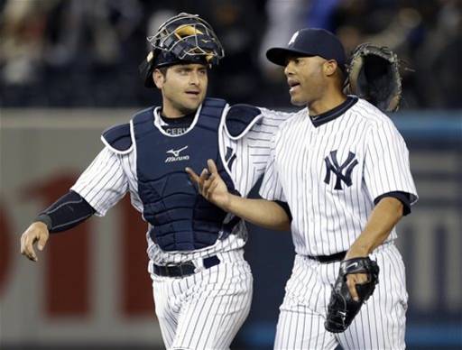 New York Yankees catcher Francisco Cervelli, left, puts his arm around Yankees relief pitcher Mariano Rivera after Rivera earned the save in their 4-2 victory over the Boston Red Sox in a baseball game at Yankee Stadium in New York, Thursday, April 4, 2013