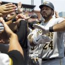 Pittsburgh Pirates' Pedro Alvarez is congratulated by teammates in the dugout after hitting a grand slam during the first inning of a baseball game against the St. Louis Cardinals Saturday, June 30, 2012, in St. Louis. (AP Photo/Jeff Roberson)