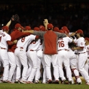 Members of the St. Louis Cardinals celebrate after the Cardinals' 7-0 win over the Chicago Cubs in a baseball game to clinch the NL Central title Friday, Sept. 27, 2013, in St. Louis. (AP Photo/Jeff Roberson)