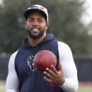 Houston Texans' Arian Foster tosses a football at NFL football training camp Saturday, July 27, 2013, in Houston. The star running back started training camp on the physically unable to perform list with a calf injury received at the beginning of organized training activities. (AP Photo/Pat Sullivan)