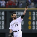 Colorado Rockies first baseman Todd Helton doffs his cap to the crowd as he takes his position on the diamond to face the Boston Red Sox in the first inning of a baseball game in Denver on Wednesday, Sept. 25, 2013. Helton, who will retire at season's end, was playing in his final home game after 17 years at first base for the Rockies. (AP Photo/David Zalubowski)