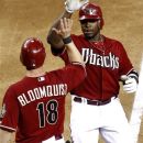 Arizona Diamondbacks' Justin Upton high fives teammate Willie Bloomquist (18) after Upton hit a two-run home run during the fifth inning of a baseball game against the Los Angeles Dodgers, Wednesday, May 23, 2012, in Phoenix. (AP Photo/Matt York)