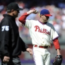 Philadelphia Phillies' Roy Halladay, right, steps off the mound as third base umpire Chad Fairchild walks over to review a home run by Miami Marlins' Adeiny Hechavarria in the third inning of a baseball game on Sunday, May 5, 2013, in Philadelphia. (AP Photo/Michael Perez)