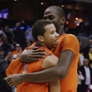 Syracuse guard Michael Carter-Williams (1) is hugged by center Baye Keita (12) after an East Regional semifinal against Indiana in the NCAA men's college basketball tournament, Thursday, March 28, 2013 in Washington. Syracuse defeated Indiana 61-50. (AP Photo/Pablo Martinez Monsivais)