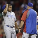 Chicago Cubs relief pitcher Carlos Marmol, left, talks on the mound during a baseball game against the Cincinnati Reds, Tuesday, April 23, 2013, in Cincinnati. (AP Photo/Al Behrman)