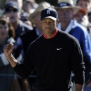 Tiger Woods raises a fist after hitting out of a bunker on the 11th hole during the fourth round of the Farmers Insurance Open golf tournament at the Torrey Pines Golf Course Monday, Jan. 28, 2013, in San Diego. (AP Photo/Gregory Bull)