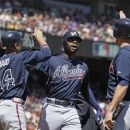 Atlanta Braves' Jason Heyward, center, is greeted by teammates Martin Prado, left, and Mike Minor, right, after hitting a three-run homer off San Francisco Giants starting pitcher Madison Bumgarner during the third inning of their baseball game in San Francisco, Saturday, Aug. 25, 2012. (AP Photo/Eric Risberg)