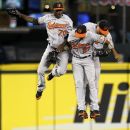 Baltimore Orioles outfielders Xavier Avery (70), Endy Chavez (27) and Nate McLouth celebrate after defeating the Seattle Mariners in a baseball game Monday, Sept. 17, 2012, in Seattle. Baltimore won 10-4. (AP Photo/Elaine Thompson)