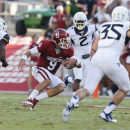 Oklahoma quarterback Trevor Knight carries between West Virginia defenders K.J. Dillon (9), Brandon Golson (2) and Nick Kwiatkoski (35) in the first quarter of an NCAA college football game in Norman, Okla., Saturday, Sept. 7, 2013. (AP Photo/Sue Ogrocki)