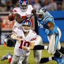 New York Giants quarterback Eli Manning (10) throws a pass under pressure from Carolina Panthers defensive tackle Dwan Edwards (92) during the first quarter of an NFL football game in Charlotte, N.C., Thursday, Sept. 20, 2012. (AP Photo/Chuck Burton)