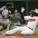 Cleveland Indians' Asdrubal Cabrera, right, scores as Chicago White Sox catcher Josh Phegley is late on the tag in the second inning of a baseball game, Monday, July 29, 2013, in Cleveland. Cabrera scored on a sacrifice fly by Carlos Santana. (AP Photo/Tony Dejak)