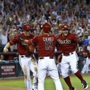 Arizona Diamondbacks' A.J. Pollock, left, celebrates his game-winning run against the Los Angeles Dodgers with teammates Eric Chavez (12) and Cody Ross during the ninth inning in a baseball game on Sunday, April 14, 2013 in Phoenix. The Diamondbacks defeated the Dodgers 1-0. (AP Photo/Ross D. Franklin)