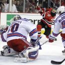 New Jersey Devils' Patrik Elias, center, of Czech Republic, takes a shot against New York Rangers goalie Henrik Lundqvist, left, of Sweden, and Ryan McDonagh during the second period of Game 3 of an NHL hockey Stanley Cup Eastern Conference final playoff series, Saturday, May 19, 2012, in Newark, N.J.  (AP Photo/Julio Cortez)