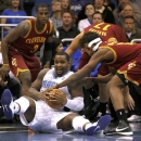 Orlando Magic forward Glen Davis, bottom, fights for the ball with Cleveland Cavaliers guard Dion Waiters (3), Anderson Varejao (17) and Tristan Thompson (13) during the first half of an NBA basketball game in Orlando, Fla., Friday, Nov. 23, 2012. (AP Photo/Reinhold Matay)