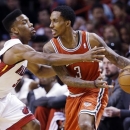 Miami Heat guard Norris Cole, left, defends against Milwaukee Bucks guard Brandon Jennings during the first half of an NBA basketball game, Tuesday, April 9, 2013, in Miami. (AP Photo/Wilfredo Lee)