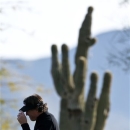 With a saguaro cactus dwarfing him in the background, Phil Mickelson tips his visor to the crowd after making a birdie on the 12th hole during the first round of the Waste Management Phoenix Open golf tournament Thursday, Jan. 31, 2013, in Scottsdale, Ariz. (AP Photo/Ross D. Franklin)