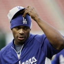 Los Angeles Dodgers' Yasiel Puig puts a hat over his hat before Game 6 of the National League baseball championship series against the St. Louis Cardinals, Friday, Oct. 18, 2013, in St. Louis. (AP Photo/David J. Phillip)