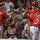 Los Angeles' Mike Trout, center, congratulates Kendrys Morales (8) and Erick Aybar (2) after scoring on a single by Chris Iannetta in the third inning of a baseball game against the Boston Red Sox at Fenway Park in Boston, Thursday, Aug. 23, 2012. (AP Photo/Charles Krupa)