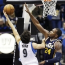 Minnesota Timberwolves' Ricky Rubio (9), of Spain, shoots a layup as Utah Jazz's Paul Millsap defends in the first quarter of an NBA basketball game, Wednesday, Feb. 13, 2013, in Minneapolis. (AP Photo/Jim Mone)