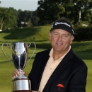 Ken Duke holds the trophy after winning the Travelers Championship golf tournament in Cromwell, Conn., Sunday, June 23, 2013. Duke won the tournament with a birdie on the second playoff hole. (AP Photo/Fred Beckham)