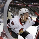 Ottawa Senators defenseman Erik Karlsson (65) grimaces as he falls to the ice after colliding with Pittsburgh Penguins left wing Matt Cooke, left, during the second period of an NHL hockey game in Pittsburgh Wednesday, Feb. 13, 2013. Karlsson was helped off the ice. (AP Photo/Gene J. Puskar)