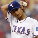 Texas Rangers' Yu Darvish of Japan adjust his cap as he pauses for a moment between batters in the first inning of a baseball game against the Seattle Mariners Monday, April 9, 2012, in Arlington, Texas. (AP Photo/Tony Gutierrez)