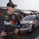 FILE - In this March 22, 2013, file photo, Denny Hamlin stands in the garage area after taking the pole position in his FedEx Express Toyota for the NASCAR Sprint Cup series Auto Club 400 auto race in Fontana, Calif. NASCAR is not penalizing Tony Stewart for scuffling with Joey Logano on pit road at California, and viewed the crash between Logano and Denny Hamlin as a racing incident. AP Photo/Reed Saxon, File)