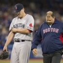 Boston Red Sox pitcher John Lackey, left, walks off the field with trainer Rick Jameyson after he was relieved in the fifth inning of a baseball game against the Toronto Blue Jays in Toronto on Saturday, April 6, 2013.(AP Photo/The Canadian Press)