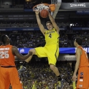 FILE - In this April 6, 2013 file photo, Michigan's Mitch McGary dunks the ball against Syracuse during the second half of the NCAA Final Four tournament college basketball semifinal game, in Atlanta. McGary was selected to The Associated Press' preseason All-America team, released Monday, Nov. 4, 2013. (AP Photo/Charlie Neibergall, File)