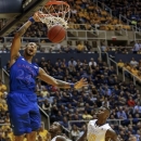 Kansas' Travis Releford (24) dunks over West Virginia's Jabarie Hinds, center, and Eron Harris (10) during the first half of an NCAA college basketball game in Morgantown, W.Va., on Monday, Jan. 28, 2013.  (AP Photo/David Smith)