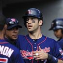 Minnesota Twins' Joe Mauer high fives his teammates after scoring during the sixth inning of a baseball game against the Detroit Tigers at Comerica Park in Detroit, Sunday, Sept. 23, 2012. (AP Photo/Carlos Osorio)