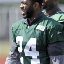 New York Jets cornerback Darrelle Revis smiles as he leaves the practice field on opening day of their NFL football training camp Friday, July 27, 2012, in Cortland, N.Y. (AP Photo/Bill Kostroun)