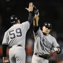 New York Yankees' Russell Martin, right, high-fives third base coach Rob Thomson as he rounds the bases after hitting a solo home run in the ninth inning of Game 1 of the American League division baseball series against the Baltimore Orioles on Sunday, Oct. 7, 2012, in Baltimore. New York won 7-2. (AP Photo/Nick Wass)
