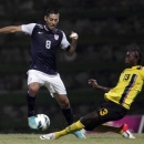 US Clint Dempsey, left, fis challenged by Antigua and Barbuda's Tamorley Kaharie Thomas during a 2014 World Cup qualifying soccer match in St. John, Antigua and Barbuda, Friday, Oct. 12, 2012. (AP Photo/Ricardo Arduengo)