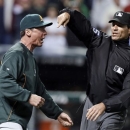 Umpire Angel Hernandez, right, ejects Oakland Athletics manager Bob Melvin for arguing a call in the ninth inning of a baseball game against the Cleveland Indians on Wednesday, May 8, 2013, in Cleveland. Melvin argued a double by Adam Rosales was a home run but the umpires upheld the call after a video review. The Indians won 4-3. (AP Photo/Mark Duncan)