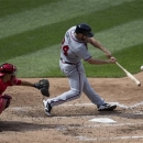 Atlanta Braves' Evan Gattis, right, hits an RBI-sacrifice fly during the sixth inning of a baseball game against the Washington Nationals at Nationals Park, Sunday, April 14, 2013, in Washington. The Braves defeated the Nationals 9-0. (AP Photo/Evan Vucci)