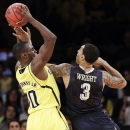 Michigan guard Tim Hardaway Jr., (10) grabs a rebound from Pittsburgh guard Cameron Wright (3) in the first half of their NCAA college basketball game in the NIT Season Tip-Off at Madison Square Garden in New York, Wednesday, Nov. 21, 2012. (AP Photo/Kathy Willens)