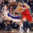 FILE - In this Feb. 20, 2012, file photo, Phoenix Suns center Marcin Gortat, left, of Poland, falls backward to the floor as Washington Wizards center JaVale McGee, right, is called for a charge in the third quarter of an NBA basketball game in Phoenix. The NBA will penalize flopping this season, fining players for repeated violations of an act a league vice president says has 
