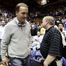 Indianapolis Colts quarterback Peyton Manning walks along the baseline prior to a an NCAA college basketball game between Duke and North Carolina in Durham, N.C., Saturday, March 3, 2012. (AP Photo/Gerry Broome)