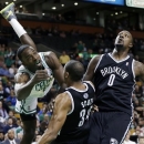 Boston Celtics' Jeff Green goes down after driving against Brooklyn Nets' Carleton Scott (34) and Andray Blatche during the first half of an NBA preseason basketball game in Boston, Tuesday, Oct. 16, 2012. (AP Photo/Elise Amendola)